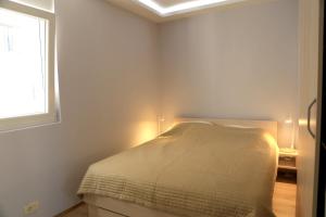 a white bedroom with a bed and a window at One bedroom appartement at Tivat 200 m away from the beach with wifi in Tivat