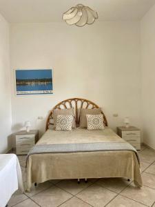 una camera da letto con un grande letto con due comodini di PIACENTINI - Apulia Home a San Pietro in Bevagna