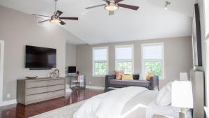a bedroom with a bed and a tv and a couch at Casa Swinton in Delray Beach
