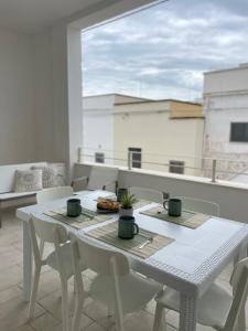 un tavolo bianco e sedie sul balcone di PIACENTINI - Apulia Home a San Pietro in Bevagna