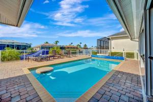 a swimming pool with a picnic table and chairs next to a house at Marco Beach Escape in Marco Island