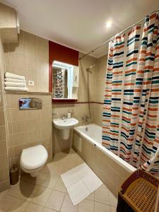 ein Badezimmer mit einem WC, einem Waschbecken und einer Badewanne in der Unterkunft Royal Bay Studio Alex in Sweti Wlas