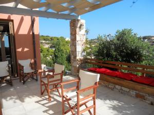 a patio with chairs and a table and a view at Charming house with sea view in Chrousa, fenced garden in Chrousa