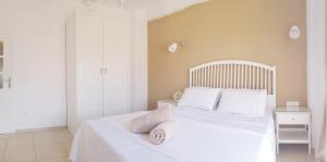 a bedroom with a white bed with towels on it at Katy's Luxury Aparments in Kavros