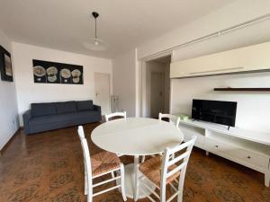 een woonkamer met een tafel en stoelen en een bank bij Homiday - Sanpà 23 in Pineto