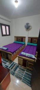 two beds in a room with purple mattresses at شاليه للايجار بقرية جراند هيلز الساحل الشمالى ٣ غرف بإطلاله مباشره على البول in Qaryat Shurūq