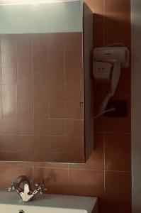 een badkamer met een wastafel en een zeepdispenser bij 7 LAKES Aparthotel in Burolo