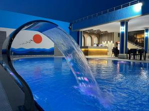 una fuente de agua en una piscina por la noche en Sun City Hotel & Spa Naftalan, en Naftalan