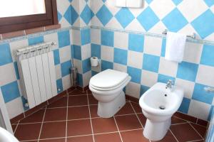 baño azul y blanco con aseo y lavamanos en 2 bedrooms appartement with enclosed garden and wifi at Nicolosi, en Nicolosi