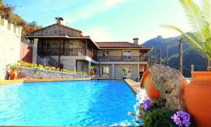 uma casa com piscina em frente a uma casa em 3 bedrooms villa with private pool enclosed garden and wifi at Terras de Bouro em Terras de Bouro