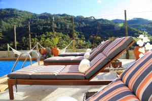 um grupo de espreguiçadeiras sentados em cima de uma piscina em 3 bedrooms villa with private pool enclosed garden and wifi at Terras de Bouro em Terras de Bouro