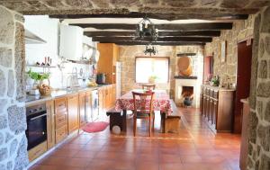 uma cozinha com uma mesa e uma cozinha com uma parede de pedra em 3 bedrooms villa with private pool enclosed garden and wifi at Terras de Bouro em Terras de Bouro
