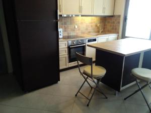 eine Küche mit einem schwarzen Kühlschrank sowie einem Tisch und Stühlen in der Unterkunft Sea View in Alikí