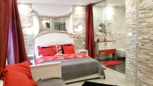 a bedroom with a bed with red pillows and a mirror at Welcoming Villa in Vantačići with Pool and Sea View in Vantačići +30 photos