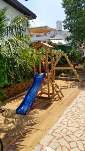 a playground with a blue slide in a yard at Welcoming Villa in Vantačići with Pool and Sea View in Vantačići