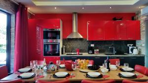 a kitchen with a wooden table and red cabinets at Welcoming Villa in Vantačići with Pool and Sea View in Vantačići