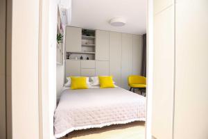 a bedroom with a bed with yellow pillows at Hajduk & St. Joseph in Split