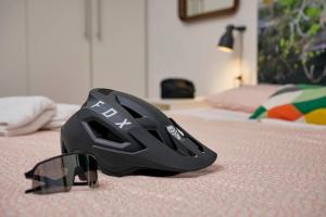 kask i okulary siedzące na łóżku w obiekcie Casa al Pozzo w mieście Riva del Garda +1 zdjęcie