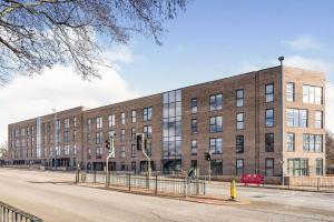 a large brick building on the side of a street at Modern 2 Bedroom Apartment Manchester Media City in Manchester