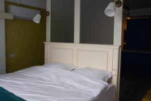 Bett mit weißem Kopfteil in einem Zimmer in der Unterkunft Blue Joy Bukovina Aparthotel in Suceava