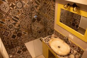 ein Bad mit einem Waschbecken und einem Spiegel in der Unterkunft Blue Joy Bukovina Aparthotel in Suceava