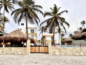 un complejo con palmeras y piscina en Sereni San Bernardo Hotel Playa, en San Bernardo del Viento