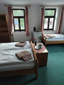 a bedroom with two beds and a table with towels at Penzion My Lady II in Heřmanice