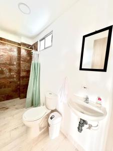 a white bathroom with a toilet and a sink at Sereni San Bernardo Hotel Playa in San Bernardo del Viento