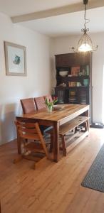 a dining room with a wooden table and a couch at Villa Augustina in Fürstenfeldbruck