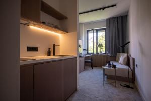 una cucina con lavandino e un divano in una camera di Bloom Suites a Pristina