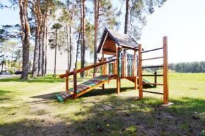 un parque infantil de madera con un tobogán en un parque en Duplex Apartment Vilte, en Druskininkai