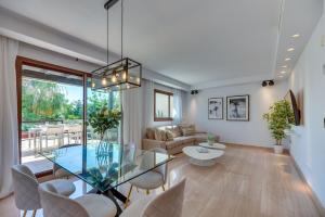 a living room with a glass table and chairs at VACATION MARBELLA I 300 SQM Penthouse, Private Swimming pool, BBQ, WiFi in Marbella