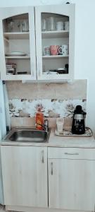 a kitchen with white cabinets and a sink at Napfény Apartmanház Balatonberény in Balatonberény