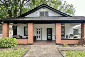 una casa bianca con il tetto nero e un portico di Adair Park Bungalow ad Atlanta