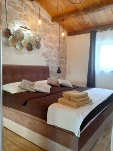 1 dormitorio con 2 camas y pared de piedra en 3 bedrooms villa with private pool enclosed garden and wifi at Ripenda Verbanci 5 km away from the beach, en Plomin