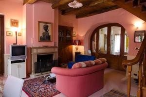 a living room with a red couch and a fireplace at 2 bedrooms house with jacuzzi enclosed garden and wifi at Decollatura in Decollatura