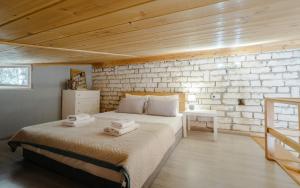 a bedroom with a bed and a brick wall at Kritamos Luxury Apartment in Chrysi Ammoudia