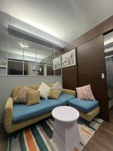 a living room with a couch and a table at Apartment in Air Residences, Makati with wifi, Netflix, pool, mall and more in Manila