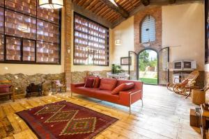 uma sala de estar com um sofá vermelho num quarto grande em 2 bedrooms appartement with shared pool jacuzzi and wifi at Bottega Genovini em Sorrezzana