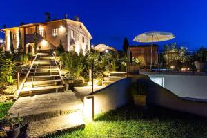 uma casa com escadas e um guarda-chuva à noite em 2 bedrooms appartement with shared pool jacuzzi and wifi at Bottega Genovini em Sorrezzana