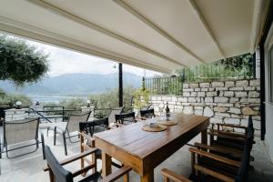 a patio with a wooden table and chairs at Kritamos Luxury Apartment in Chrysi Ammoudia