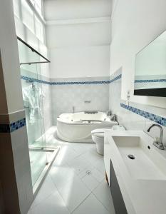 a white bathroom with a tub and a sink at Finca Hotel Casa Bela in Santa Fe de Antioquia