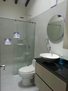 ein Badezimmer mit einem WC, einem Waschbecken und einem Spiegel in der Unterkunft ALAMEDA MI DESCANSO in Carmen de Viboral