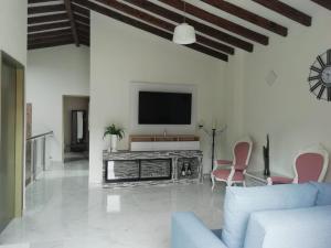 ein Wohnzimmer mit einem TV an einer weißen Wand in der Unterkunft ALAMEDA MI DESCANSO in Carmen de Viboral
