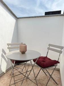 2 sillas y una mesa en el patio en Intero Appartamento Ristrutturato - Voghera en Voghera
