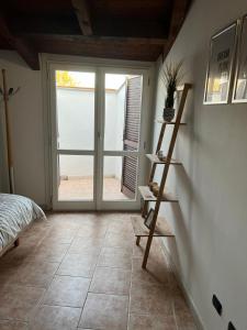 a bedroom with a large glass door and a tiled floor at Intero Appartamento Ristrutturato - Voghera in Voghera