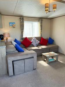 a living room with a couch and a table at GOOD SHIP LOLLIPOP LODGE - Birchington-on-Sea - 6 mins drive to Minnis Bay Beach in Kent