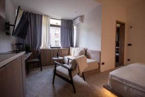una camera d'albergo con un divano e un letto di Bloom Suites a Pristina