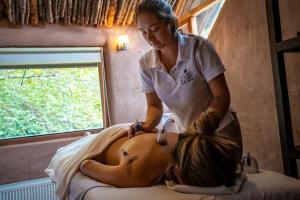 una mujer recibiendo un masaje de espalda en una cama en Hotel Altiplanico Cajón del Maipo, en San José de Maipo