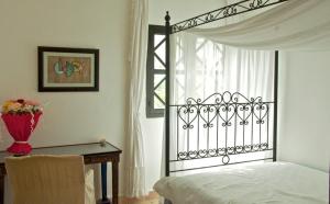 a bedroom with a bed and a table and a window at Dar Rass El Maa in Chefchaouene
